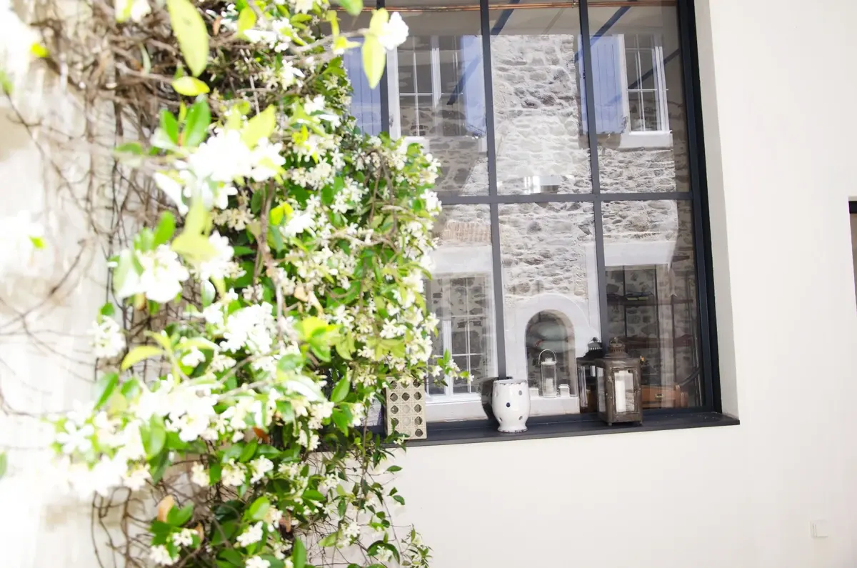 Patio avec verrière et façade en pierre aux Sables-d’Olonne par AT Design